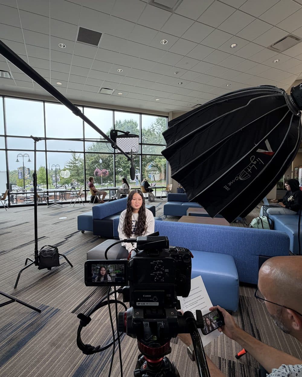 Camera and lights set up for an interview in a building lobby
