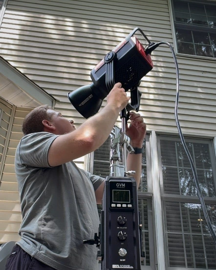 Alex adjusting a light outdoors